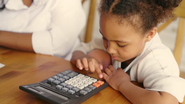 Little black girl examining calculator, closeup portrait, education and studying. Preschooler child studying mathematic, pressing buttons, addition and subtraction in primary school, accounting