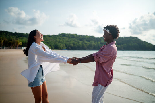 Carefree couple enjoying a tropical beach vacation, laughing making unforgettable memories together
