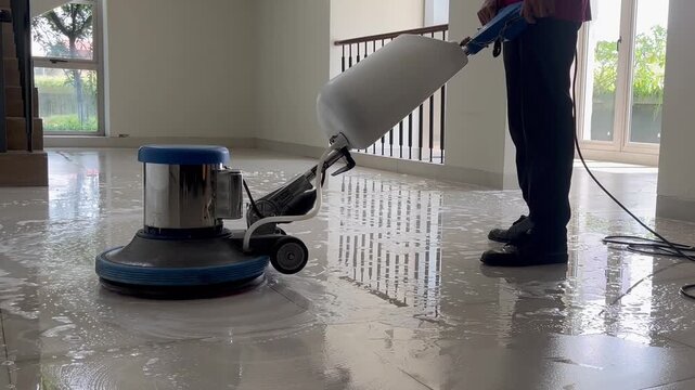 Professional worker cleaning floor with polishing machine