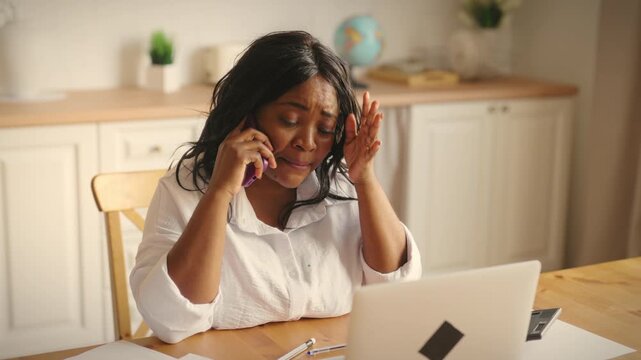 Annoyed female client calling to supplier and arguing, portrait woman at home. Emotional african american lady calling in customer service department, home office for freelancer, modern work online