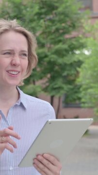 Woman Doing Video Chaton Tablet while Walking in Street, Vertical Video