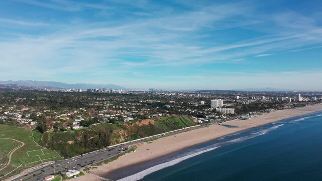 Aerial view of santa monica beach with pacific palisades and city skyline background.