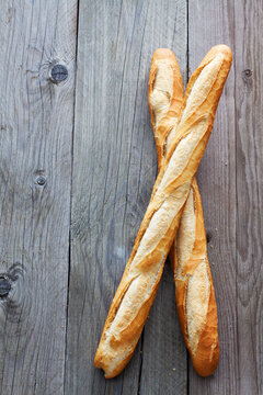 Two French baguettes on grey wood