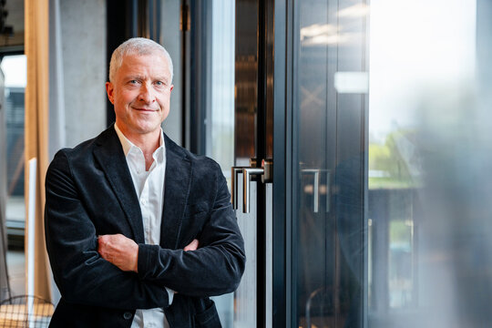 A smiling businessman shows confidence in the office