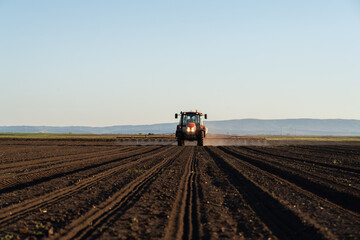 Tractor spraying agricultural field with boom sprayer © Dusan Kostic
