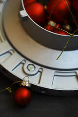 Fototapeta premium Red Christmas Ornaments on Industrial Metal Surface: Festive Holiday Decor Concept