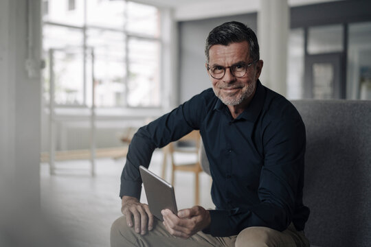 Portrait of confident mature businessman with tablet