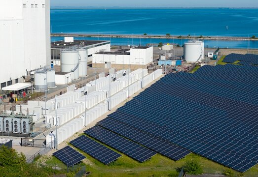 Solar panel and battery storage sit near a gas fired power station
