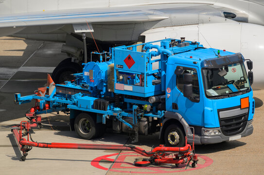 Blue truck refueling an airplane with kerosene at Amsterdam airport