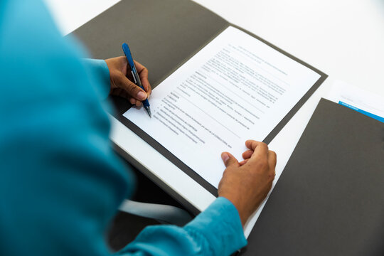 Businesswoman signing a legal contract at the office desk