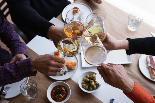 Friends hands toasting wine at restaurant