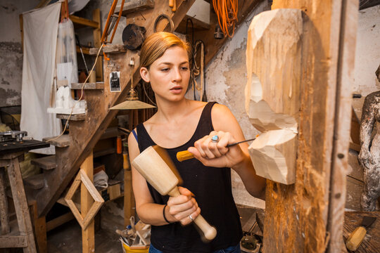 Sculptress carving wooden figure