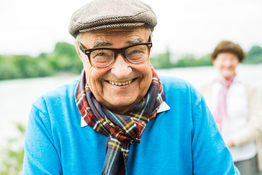 Portrait of happy senior man with glasses and cap