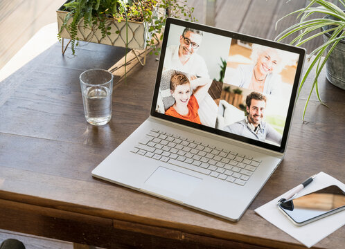 Screen of multiple people on laptop during video call at home