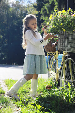 Little Girl Enjoying a Sunny Day with a Bicycle in a Scenic Garden