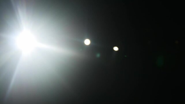 Flashes and glare on a black background, spotlight on the concert