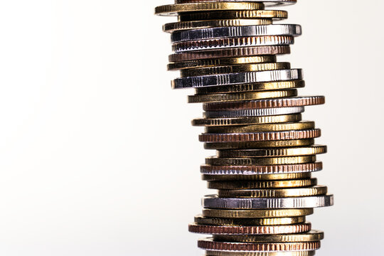 Leaning Stack of Assorted Coins Symbolizing Financial Risk and Investment Growth
