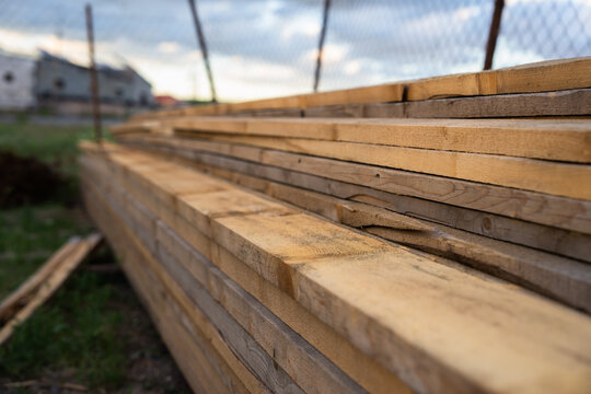Stacked construction boards of various types and sizes used for building and renovation projects, showcasing raw materials essential for carpentry, woodworking, and structural development work.
