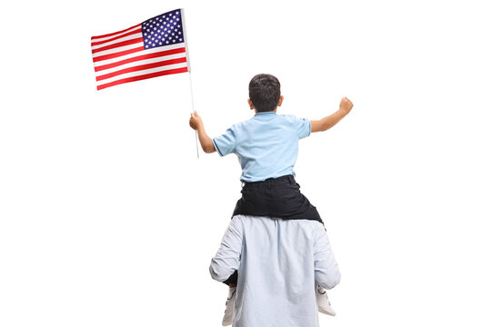 Little boy waving an american flag on his fathers shoulders from behind