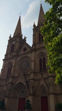 Sacred Heart Cathedral Guangzhou Gothic Side View Handheld Slow Pan Through Trees