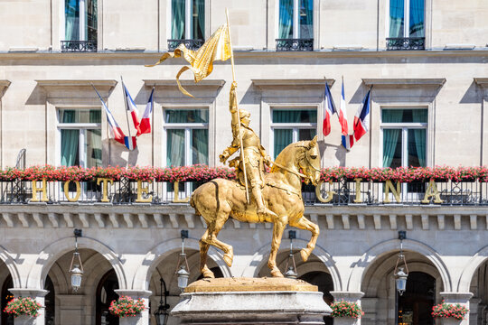 Paris, France - June 17, 2026: Side view of the gilded bronze equestrian statue of Joan of Arc by Emmanuel Fremiet, erected in the Pyramides square in 1874, with French flags in the background.