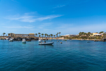 Obraz premium Tabarca island harbor showcasing boats and coastal resort during summer