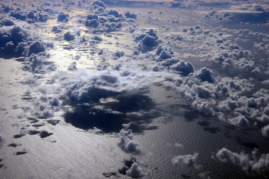 Cloud formations are reflected on the surface of the ocean in the early morning.