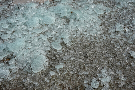 Broken glass from a safety window lies scattered on the ground.