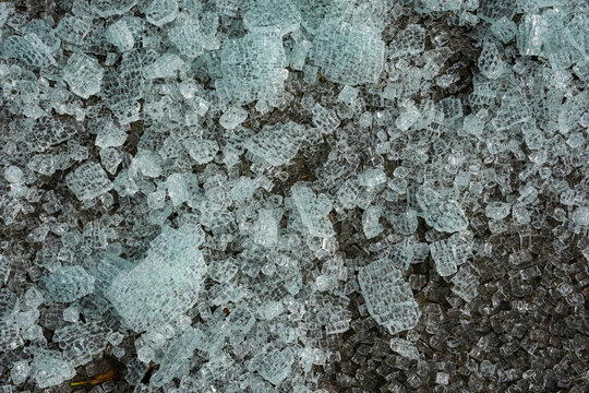 Broken glass from a safety window lies scattered on the ground.