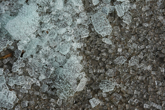 Broken glass from a safety window lies scattered on the ground.