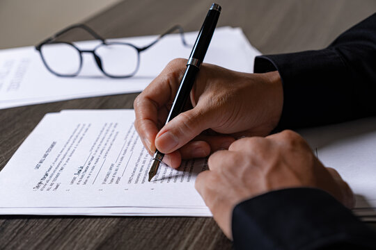 Professional in Dark Suit Drafting Last Will and Testament Document