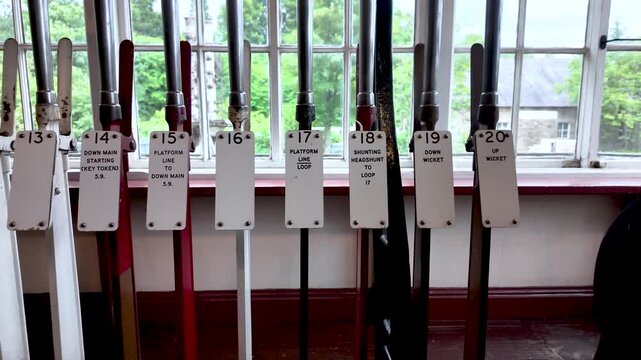 Close-up view inside a vintage railway signal box, showcasing a row of mechanical levers for train management.