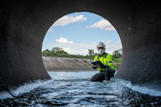 Engineer Performing Water Quality Assessment Inside Stormwater Drainage Pipeline System