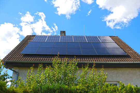 Home solar panel. Alternative energy is used for heating and water heating. Eco-friendly alternative energy for house. Residential family house suburban. Brown tile roof of home with solar panels.