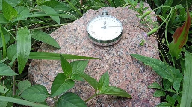 Stopwatch on agranite rock  background. Close-up of a traditional mechanical stopwatch.photo taken in malaysia