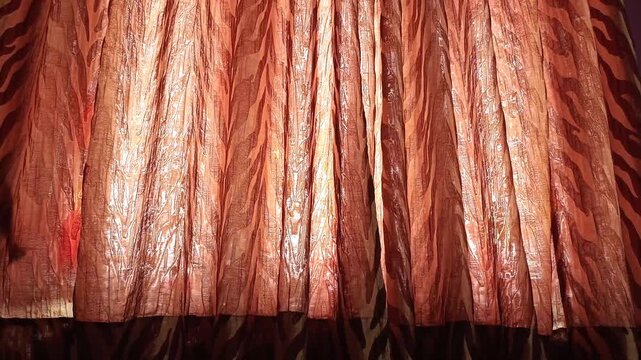 Sunlight streaming through elegant brown and orange pattern curtains in a purple bedroom interior