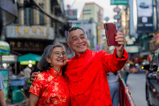 Couple takes a selfie in a busy street during a festival celebration in a city