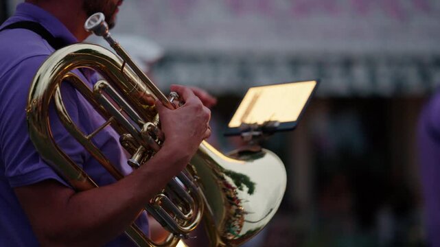 Musician playing a brass instrument during an outdoor concert, live music enhancing the atmosphere of the event