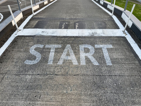 Start line for a race on an industrial road setup in a parking area during daylight hours