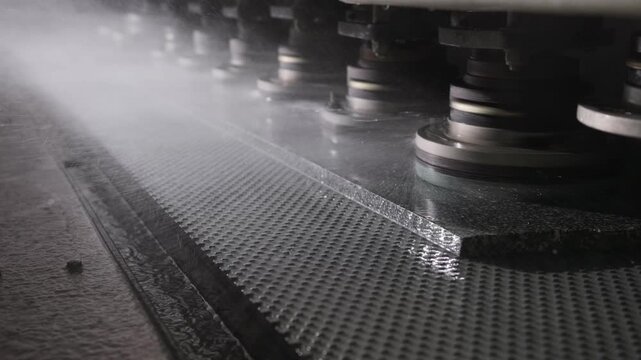 Industrial stone polishing machine grinding marble slab with water cooling in a modern factory production line
