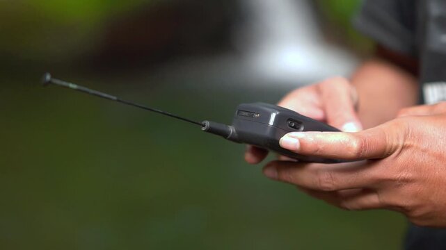 Operating a 90s mobile phone, a communication device that still relied on an antenna to pick up a signal.