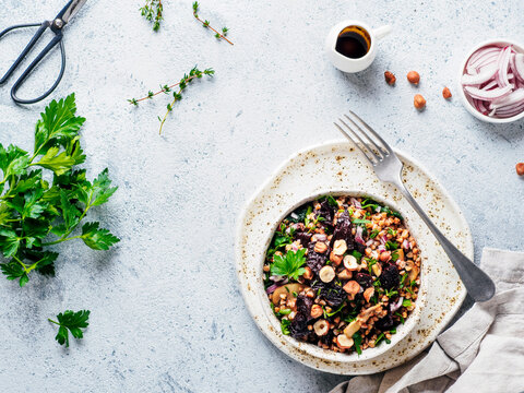 Vegetarian diet salad with beet, buckwheat grains, mushrooms, red onion and fresh herbs in bowl. Warm buckwheat and beetroot salad on gray concrete background. Top view. Copy space
