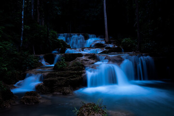Cascading Waterfall Flows Through Lush Tropical Rainforest At Huai Mae Khamin Waterfall Kanchanaburi Thailand © SHUTTER DIN