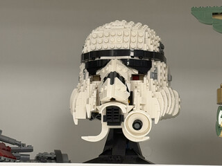 Obraz premium Lego stormtrooper helmet model displayed on a shelf, showing a detailed white and black sci-fi character head made from building bricks