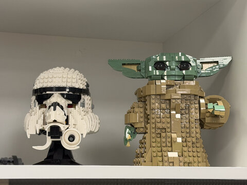 Lego star wars stormtrooper helmet and baby yoda figure displayed on a shelf in a home interior.
