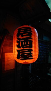 夜の居酒屋の軒先に灯る赤い提灯