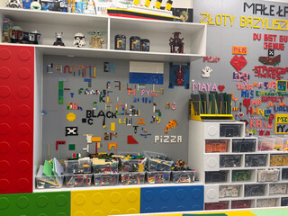 Obraz premium Colorful lego display wall with storage bins, shelves, and handmade brick art in a toy workshop or playroom