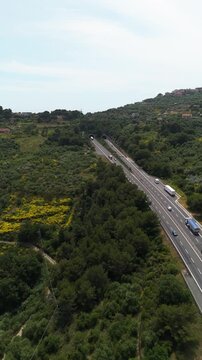 Vertical drone shot of trucks driving on the A10 E80 motorway in Liguria, Italy