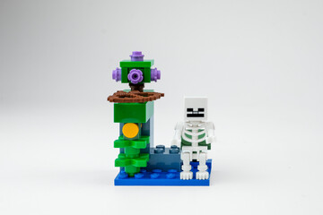 Obraz premium A Minecraft-style skeleton toy with a bow stands beside a fantasy block structure on a white background on Apr 13, 2026 in Jakarta, Indonesia