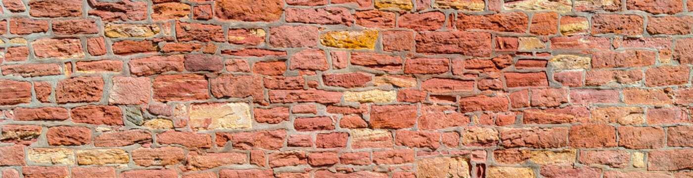 Red sandstone brick wall texture background panoramic ancient stone block masonry banner
